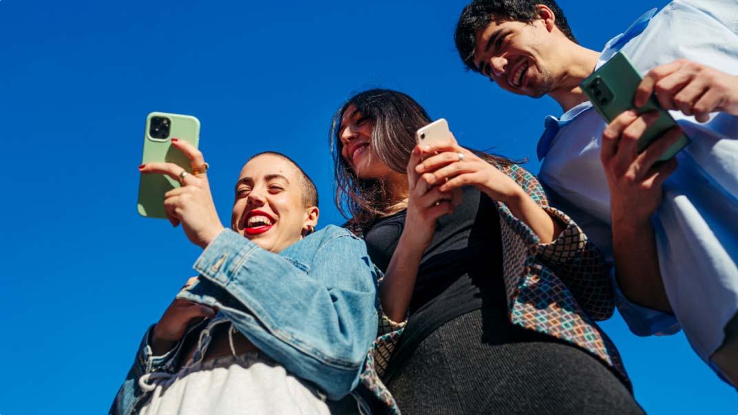 three persons using smartphones